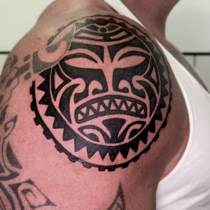 Tatuaje polinesio circular en el hombro, estilo tribal blackwork